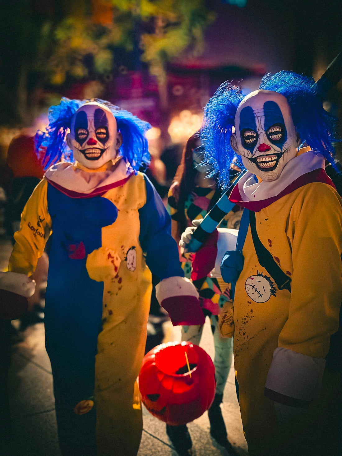 Two creepy clowns with blue hair and colorful costumes