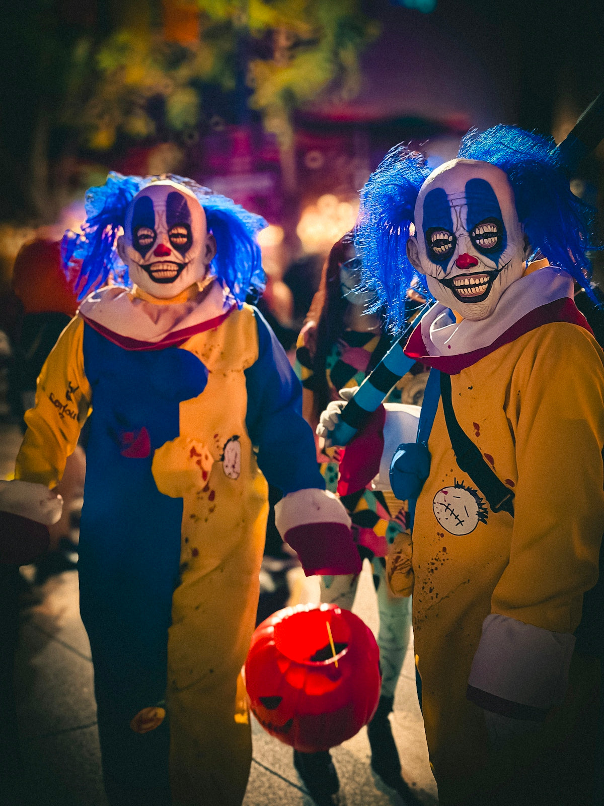 Two creepy clowns with blue hair and colorful costumes